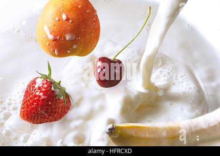 Frutto di cadere in latte - fragola, ciliegia, banana e pesca Foto Stock