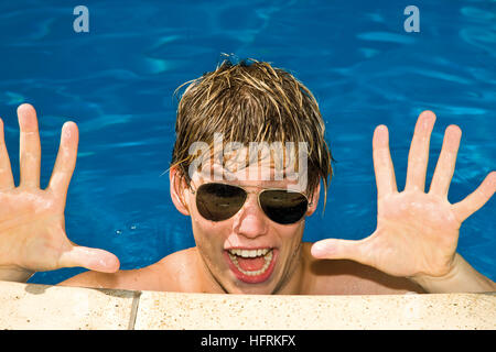 Cool ragazzo indossa occhiali da sole in una piscina Foto Stock