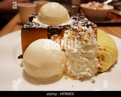 Decorate il miele e il cioccolato la lava su pane tostato con gelato alla vaniglia e di banana e panna montata nel ristorante della Thailandia Foto Stock