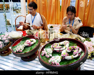 Uomo tailandese e woamn rendendo garland per mostrare alla gente di cultura tradizionale festival tailandese il 16 novembre 2016 a Nonthaburi, Tailandia Foto Stock