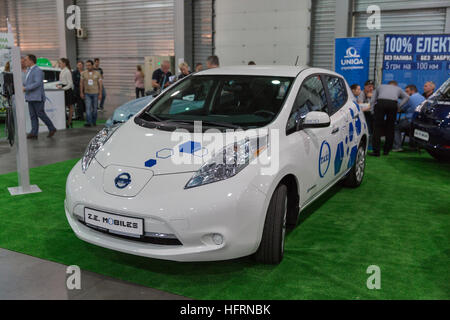 Visitatori visitare Z.E. Telefoni cellulari Eco compagnia di Taxi con stand Nissan Leaf auto elettrica ibrida al 1° International Trade Show. Foto Stock