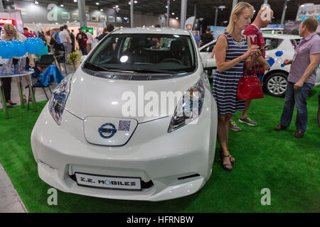 Visitatori visitare Z.E. Telefoni cellulari Eco compagnia di Taxi con stand Nissan Leaf auto elettrica ibrida al 1° International Trade Show. Foto Stock