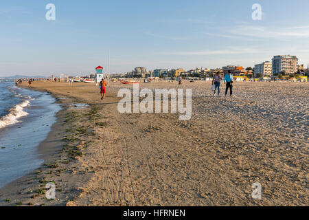 La gente non riconosciuto a piedi lungo la spiaggia di sabbia della città. Situato sul mare Adriatico è una delle più famose località balneari. Italia Foto Stock