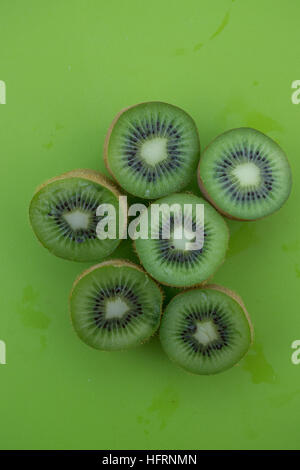 La vista di kiwi catted su metà sulla superficie verde Foto Stock