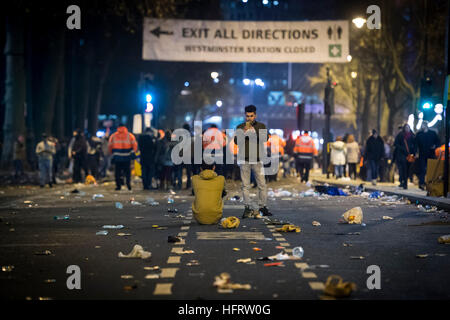 Festaioli scattare foto tra pile di figliata su Albert Embankment nel centro di Londra dopo la folla partì dopo i festeggiamenti di Capodanno. Foto Stock