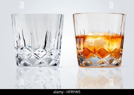 Due bicchieri perfetta di whiskey e ghiaccio isolato su sfondo bianco. Tracciato di ritaglio Foto Stock
