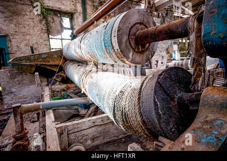 Corda ricoperte rulli accanto a un telaio in una industria tessile. Foto Stock