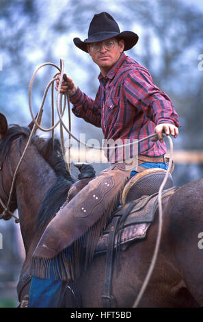Un cowboy con un lazo presso un allevamento bovino roundup e il branding in Belle Fourche, Dakota del Sud Foto Stock