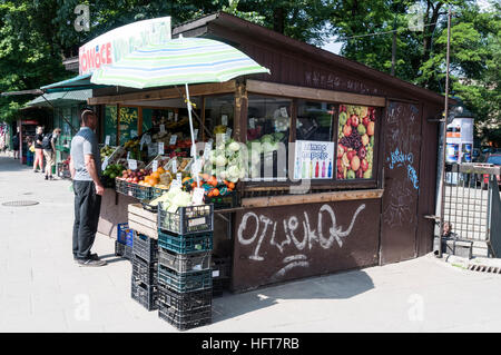 Un cliente in uno dei tanti street chiosco, comune in Europa orientale, verdure di vendita di sigarette in Krskow, Polonia Foto Stock