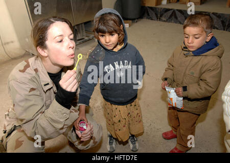 070116-N-8218W-030 Baghdad, Iraq (GEN. 16, 2007) - USA Air Force 1 Lt. Lea Ann Fracasso soffia bolle per alcuni bambini iracheni presso il civile operazioni militari centro (CMOC) vicino a Baghdad in Iraq. Al CMOC iracheni locali possono venire a ricevere attenzione medica da U.S. I medici militari e i bambini ricevono giocattoli, abbigliamento e forniture scolastiche donati dagli americani. La Fracasso è di servire con la Task Force-134 detenuto operazioni in Iraq ed è assegnato a Wright-Paterson Air Force Base in Ohio. Stati Uniti Navy foto di Senior Chief la comunicazione di massa specialista Jerry Woller (rilasciato) Navy US 070116- Foto Stock