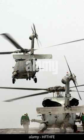 070316-N-7130B-163 Mare delle Filippine (16 marzo 2007) - Una SH-60F Seahawk, assegnato al 'Cavalieri Neri' di elicottero Anti-Submarine Squadron (HS) 4, prende il volo come un HH-60H Seahawk attende il segnale di sollevamento fuori dalla USS Ronald Reagan (CVN 76). Ronald Reagan Carrier Strike gruppo, con avviato Carrier aria Wing (CVW) 14, viene distribuito a sostegno delle operazioni nel 7 ° Flotta area di responsabilità. Stati Uniti Foto di Marina di Massa lo specialista di comunicazione 2a classe Aaron onere (rilasciato) Navy US 070316-N-7130B-163 una SH-60F Seahawk, assegnato al Foto Stock