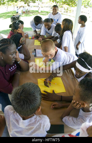 070719-N-6674H-081 PEARL HARBOR, Hawaii (19 luglio 2007) - Yeoman 1a classe Nakia Habson, un farmaco di volontariato educazione della gioventù (sfidare) mentor, pullman bambini iscritti nella fase-Summer Camp come lavorano come una squadra per disegnare immagini raffiguranti i giorni eventi durante un team building esercitare all'Caitlin Centro Comunitario alla stazione navale Pearl Harbor. Insultare è un due-fase programma progettato per promuovere il positivo, sano, esente da farmaco di stili di vita in bambini di 9-12 anni attraverso l'educazione in materia di droghe, leadership e sviluppo dei personaggi, ruolo positivo a modello mentoring e comunicazione alla comunità. Stati Uniti Foto di Marina Foto Stock