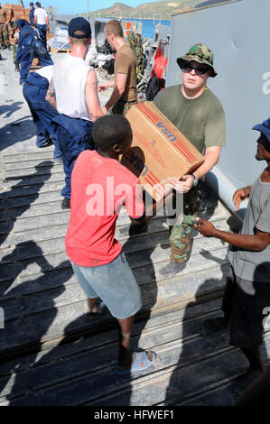 080922-N-7955L-078 GONAIVES, Haiti (sett. 22, 2008) Stati Uniti i membri del servizio assegnato all'assalto anfibio nave USS Kearsarge (LHD 3) e civili haitiani spostare le scatole di olio di cottura durante una assistenza umanitaria missione per aiutare gli haitiani colpiti da recenti uragani. Kearsarge ha avviato il servizio degli Stati Uniti i membri provenienti da tutti i rami di militari e di un gruppo multinazionale di medici e personale di supporto. (U.S. Foto di Marina di Massa lo specialista di comunicazione di terza classe Christopher Lange/RILASCIATO) Navy US 080922-N-7955L-078 NEGLI STATI UNITI i membri del servizio assegnato all'assalto anfibio nave USS Kearsarge (LHD 3) Foto Stock