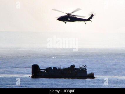 Un elicottero MH-60S Knighthawk vola sopra un cuscino d'aria di un mezzo da atterraggio dalla USS New Orleans (LPD 18) durante un esercizio di certificazione con il Boxer Expeditionary Strike Group prima dello spiegamento. Foto Stock