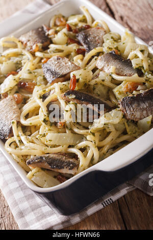 Pasta siciliana bucatini con sarde, finocchio, uvetta e pinoli vicino fino in teglia da forno verticale. Foto Stock