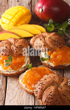 Panini dolci con marmellata di mango, burro e menta vicino sul piano verticale. Foto Stock