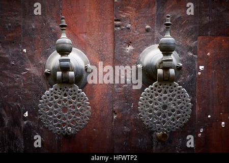 Elaborare le maniglie delle porte / battenti su porte in legno del Bou Inania moschea nella medina di Fez, in Marocco. Foto Stock