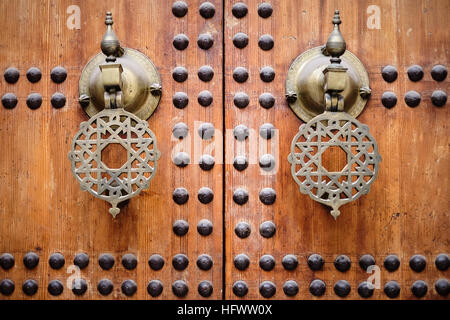 Elaborare le maniglie delle porte / battenti in legno chiodati porte della moschea di Kairaouine nella medina di Fez, in Marocco. Foto Stock