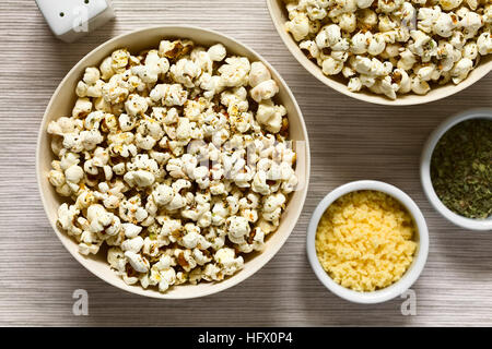 In casa fresca popcorn salati con formaggio e aglio, origano essiccato in ciotole, fotografato il sovraccarico con luce naturale Foto Stock