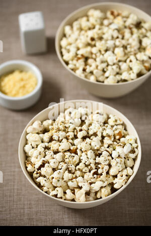 In casa fresca popcorn salati con formaggio e aglio, origano essiccato in ciotole, fotografati con luce naturale (messa a fuoco selettiva) Foto Stock