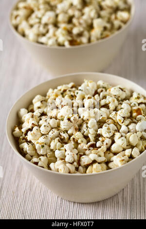 In casa fresca popcorn salati con formaggio e aglio, origano essiccato in ciotole, fotografati con luce naturale (messa a fuoco selettiva) Foto Stock