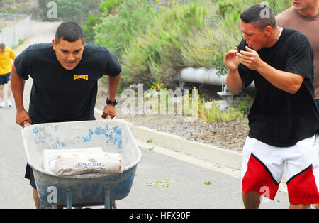 090508-N-2183K-046 San Diego, California (8 maggio 2009) applauditi dai suoi compagni di squadra, Engineering Aide Constructionman Telly Armstrong spinge un cilindretto della ruota riempita con 188 chili di impasto cementizio in salita durante il Seabee sfida la concorrenza alla Base Navale di Point Loma. La sfida Seabee è tenuta annualmente e permette di marinai provenienti da diversi comandi in tutta la regione per incontrare e partecipare a una competizione amichevole per affilare real-world le competenze utilizzate per sostenere la missione della Marina. (U.S. Foto di Marina di Massa lo specialista di comunicazione 2a classe Dustin Kelling/RILASCIATO) Navy US 090508-N-2183K-046 applauditi b Foto Stock