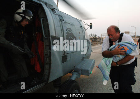 Un membro della FEMA Urban Search and Rescue Task Force trasferisce un bambino a un SH-60 Seahawk della Marina per l'evacuazione medica durante le operazioni di soccorso dell'uragano Katrina con Helicopter Anti-Submarine Squadron 15. Foto Stock