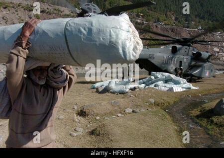 051019-N-8796S-126 Balikot Pakistan (ott. 19, 2005) --- un anziano uomo pakistano porta una tenda lontano dalla U.S. Navy MH-53 mare Dragon dalla miniera di elicottero contromisura Squadron 15 (HM-15). Il governo degli Stati Uniti sta partecipando a una multinazionale di assistenza umanitaria e di supporto di piombo di sforzo da parte del governo pakistano per portare aiuto alle vittime del terremoto che ha colpito la regione Ott 8 2005. Stati Uniti Navy foto di fotografi Mate in seconda classe (AW/SW) Timothy Smith (rilasciato) Navy US 051019-N-8796S-126 un anziano uomo pakistano porta una tenda lontano dalla U.S. Navy MH-53 S Foto Stock