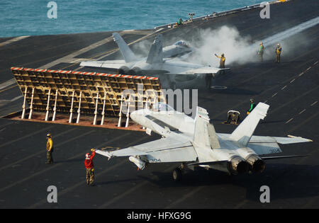 051118-N-7241L-012 Golfo Persico (nov. 18, 2005) - Un'F/A-18 Hornet assegnati al 'Golden Warriors' di Strike Fighter Squadron otto sette (VFA-87) si prepara a lanciare dal numero due bow catapulta come una F/A-18 assegnato al 'Valions' di Strike Fighter Squadron uno cinque (VFA-15) Taxi in posizione dietro la catapulta jet blast deflettore (JBD) a bordo della USS Theodore Roosevelt CVN (71). Roosevelt e avviato Carrier aria Wing otto (CVW-8) sono attualmente in corso nel Golfo Persico a supporto di operazione Cortina d'acciaio, un giunto USA-IRAQ offensiva militare volto a prevenire le cellule di Al Qaeda Foto Stock