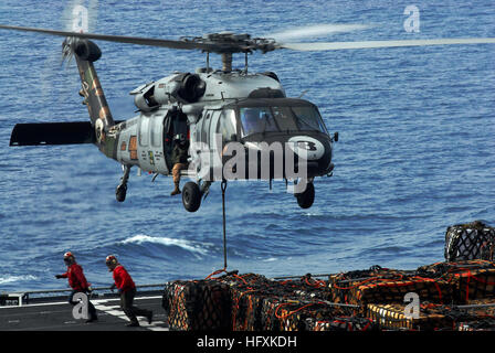 090616-N-2475A-176 GOLFO DI ALASKA (16 giugno 2009) marinai eseguire chiara dell'area di atterraggio dopo l'attacco di un carico pendente al fondo di un MH-60S Sea Hawk dalla Eightballers di elicottero di mare squadrone di combattimento (HSC) 8 come si libra sopra il ponte di volo di USNS Ponte (T-AOE 10) di prelievo di pallet di materiali per il trasferimento alla Nimitz-class portaerei USS John C. Stennis (CVN 74) durante un rifornimento in mare. Stennis e Carrier aria Wing (CVW) 9 partecipano al bordo settentrionale 2009, un esercizio congiunto che si concentra sulla rilevazione e il monitoraggio delle unità in mare e in aria e a terra. (Brevetto statunitense n. Foto Stock