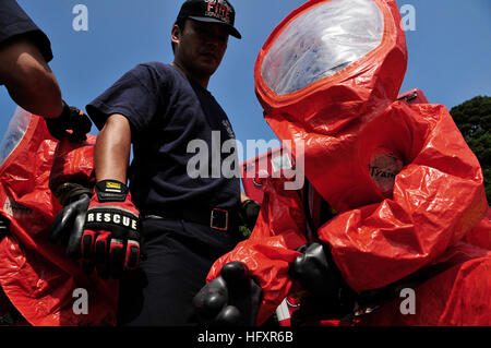 I vigili del fuoco regionali del CNFJ indossano le tute protettive per rispondere alle simulate fuoriuscite di sostanze chimiche durante l'esercitazione annuale di prevenzione dei disastri a Camp Ainoura in coordinamento con le attività della flotta squadra medica di emergenza Sasebo. Foto Stock