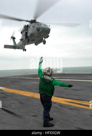 Un marinaio a bordo della portaerei USS Harry Truman segnali pilota di un HH-60H Sea Hawk elicottero assegnato per il polveroso cani di elicottero Squadron 7 che è chiaro il lift-off. USS Harry Truman DVIDS225043 Foto Stock