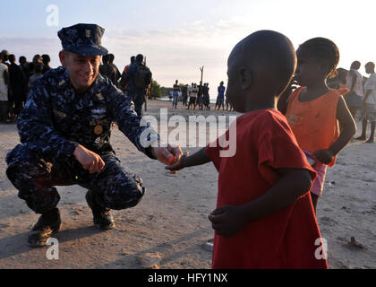 100204-N-4124C-001 ILE DE LA GONAVE, Haiti, Haiti (feb. 4, 2010) Il comando Master Chief Callison Jack, assegnati alle visite-missili cruiser USS Normandia (CG 60), dà la caramella per un ragazzo di Haiti durante la valutazione e l'assistenza visitare il sito web come parte di una serie di aiuti umanitari consegne sull'isola di La Gonave, Haiti. La Normandia è condurre missioni umanitarie e di soccorso in caso di catastrofe operazioni come parte dell'operazione Unified risposta dopo un terremoto di magnitudine 7.0 hanno provocato gravi danni in ed intorno a Port-au-Prince, Haiti gen. 12. (U.S. Navy foto di alfiere Adam R. Cole/RILASCIATO) Navy US 100204-N-4124C- Foto Stock