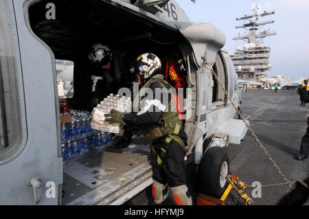 110314-N-NB544-022 OCEANO PACIFICO (14 marzo 2011) velisti assegnati ai Cavalieri Neri di Anti-Submarine Squadron (HS) 4 alimenta il carico su un HH-60H Sea Hawk elicottero a bordo della portaerei USS Ronald Reagan (CVN 76). Ronald Reagan è al largo delle coste del Giappone il rendering di assistenza umanitaria a seguito di un ordine di grandezza 8.9 il terremoto e lo tsunami. (U.S. Foto di Marina di Massa lo specialista di comunicazione di terza classe Kyle Carlstrom/RILASCIATO) Usn@sendai Foto Stock