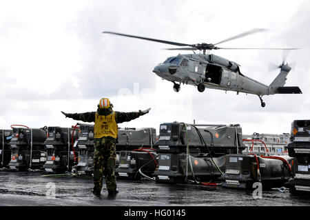 110828-N-VF562-331 OCEANO PACIFICO (Agosto 28, 2011) un marinaio assegnato al dipartimento dell'aria della portaerei USS Ronald Reagan CVN (76) guide un MH-60S Sea Hawk elicottero assegnato al Wild Card di elicottero di mare squadrone di combattimento (HSC) 23 durante un trasferimento di munizioni. Ronald Reagan è in corso negli Stati Uniti 7 flotta area di responsabilità. (U.S. Foto di Marina con marinaio Nolan Kahn/RILASCIATO) Navy US 110828-N-VF562-331 un marinaio assegnato al dipartimento dell'aria della portaerei USS Ronald Reagan CVN (76) guide un MH-60S Sea Hawk egli Foto Stock