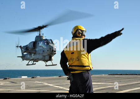 111130-N-YX169-130 OCEANO ATLANTICO (nov. 30, 2011) di aviazione di Boatswain Mate Airman Michael Babers dirige un AH-1W Super elicottero Cobra dal 2 aeromobili Marina Wing, Marine Air-Ground Task Force, II Marine Expeditionary forze, come si solleva dal trasporto anfibio dock nave USS Ponce (LPD 15). Il Ponce dipartimento dell'aria ha supervisionato oltre 39.000 di sicuro gli sbarchi e lancia dalla nave da guerra negli ultimi 40. Ponce verrà smantellata nel 2012. (U.S. Foto di Marina di Massa lo specialista di comunicazione 1a classe Natanaele Miller/RILASCIATO) Navy US 111130-N-YX169-130 un elicottero depa Foto Stock