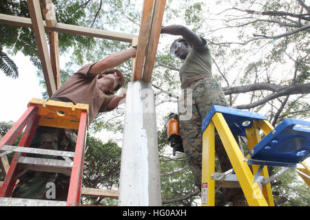 111212-A-IP644-113 LA UNION, El Salvador (12 dicembre 2011) Builder 2a classe Phillip Grindstaff, assegnato a Navy Mobile Battaglione di costruzione (NMCB) 23, e LCpl. Ronald Russell, assegnato al distacco di Marino, sia imbarcato a bordo di Alta Velocità nave (HSV 2) Swift, utilizzare una pistola sparachiodi di balseros costante su una classe esterna essendo costruito per Centro Escolar scuola elementare. NMCB 23 è il supporto del sud della stazione di partenariato 2012, una distribuzione annuale di U.S mezzi navali negli Stati Uniti Comando Sud area di responsabilità. (U.S. Esercito foto di Spc. Jennifer Grier/RILASCIATO) Navy US 111212-A-IP6 Foto Stock