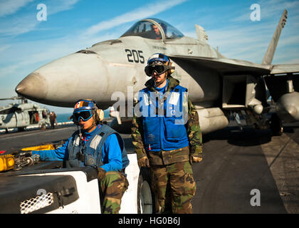 111215-N-BT887-155 GOLFO ARABICO (dec. n. 15, 2011) di aviazione di Boatswain Mate (manipolazione) 3° di classe Dan Angelo Tulabot e aviazione di Boatswain Mate (manipolazione) Airman Justin Clark posizionare un F/A-18E Super Hornet dal Tophatters di Strike Fighter Squadron (VFA) 14 a bordo della Nimitz-class portaerei USS John C. Stennis (CVN 74). John C. Stennis è distribuito negli Stati Uniti Quinta Flotta area di responsabilità condurre le operazioni di sicurezza marittima e le missioni di sostegno come parte dell'Operazione Enduring Freedom e nuova alba. (U.S. Foto di Marina di Massa lo specialista di comunicazione di terza classe Benjamin Crossley/R Foto Stock