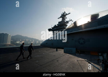 Il transito dei marinai il ponte di volo come la Nimitz-class portaerei USS Carl Vinson arriva a Hong Kong. La Carl Vinson Strike gruppo è in Hong Kong per un porto visita. USS Carl Vinson azione 111226-N-DR144-126 Foto Stock