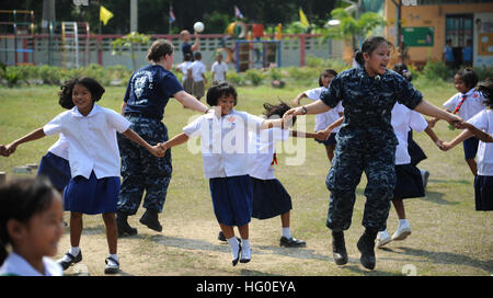 Engineman 3° di classe Victoria Moore e Engineman 3° di classe Ia Vang, entrambi assegnati alla distribuita amphibious dock landing ship USS Germantown, tenere le mani con bambini tailandesi durante la partecipazione a una comunità di un progetto di servizio durante una visita porta alla Thailandia. Germantown, con elementi imbarcato del trentunesimo Marine Expeditionary Unit è in corso dopo la partecipazione in esercizio Cobra Gold 2012, un annuale Thai-STATI UNITI co-sponsorizzato giunto e multinazionale di esercizio destinato a far avanzare la sicurezza di tutta la regione Asia Pacifico e migliorare l'interoperabilità con le nazioni partecipanti. (U.S. Navy ph Foto Stock