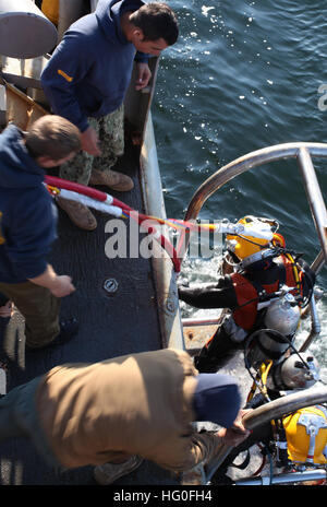 I subacquei, assegnato a Mobile Diving e unità di soccorso 2, e il giunto POW/MIA comando contabili, vengono abbassati in acqua per condurre un recupero di immergersi nel golfo di San Lorenzo. Una 50-persona del team di recupero dal JPAC, MDSU 2, e civili di marinai da la USNS benna mordente (T-ARS 53), stanno conducendo scavi subacquei alla ricerca di cinque americani che sono stati persi quando la loro costruttiva PBY-5un aereo si è schiantato nel novembre 1942. JPAC conduce la ricerca globale, recupero e le operazioni di laboratorio per identificare dispersi-per gli americani da conflitti del passato al fine di supportare il dipartimento della difesa personale Foto Stock