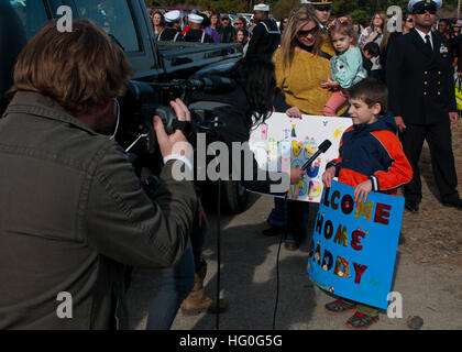 Connor Kellum, figlio della Cmdr. Eric Kellum, comandante della dock anfibio sbarco nave USS Fort McHenry (LSD) 43 viene intervistato circa i suoi padri di ritorno da una distribuzione programmata per gli Stati Uniti Sesta flotta area di responsabilità sostenere le operazioni di sicurezza marittima e di protezione del teatro gli sforzi di cooperazione. (U.S. Foto di Marina di Massa lo specialista di comunicazione 2a classe Scott Pittman/RILASCIATO) USS Fort McHenry homecoming 121130-N-FI736-061 Foto Stock