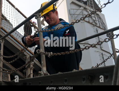 Boatswain compagno del 3° di classe Nate Peike prepara il ciglio di dock anfibio sbarco nave USS Fort McHenry (LSD 43) a seguito della nave di ritorno da una distribuzione programmata per gli Stati Uniti Sesta flotta area di responsabilità sostenere le operazioni di sicurezza marittima e di protezione del teatro gli sforzi di cooperazione. (U.S. Foto di Marina di Massa lo specialista di comunicazione 2a classe Scott Pittman/RILASCIATO) USS Fort McHenry homecoming 121130-N-FI736-064 Foto Stock