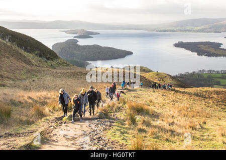 Collina conica, Balmaha, Loch Lomond, Scozia. Il 2 gennaio 2017. Meteo REGNO UNITO: famiglie godendo di un mattino luminoso a piedi fino Conic Hill - un popolare, ma insolitamente occupato Summit che si eleva al di sopra del villaggio di Balmaha. La breve salita a piedi che forma parte del West Highland Way si trova proprio sul confine delle Highland e premia i camminatori con fantastiche vedute sul Loch Lomond. Credito: Kay Roxby/Alamy Live News Foto Stock