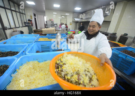 (170104) -- YANGZHOU, gen. 4, 2017 (Xinhua) -- un cuoco rende Laba congee al Daming tempio di Yangzhou, est cinese della provincia di Jiangsu, gen. 4, 2017. La Laba Festival, un Cinese tradizionale vacanza all'ottavo giorno del dodicesimo mese lunare, cadrà il 5 gennaio di quest'anno. È consuetudine in questo giorno per mangiare una speciale Laba congee, o otto tesoro porridge, usualmente realizzato con almeno otto ingredienti, che rappresentano persone di preghiere per il raccolto, di felicità e di pace. (Xinhua/Meng Delong) (wyo) Foto Stock