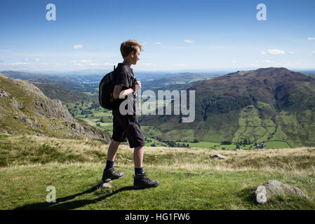 Un giovane maschio escursionista nel distretto del lago cercando la distanza da Stickle Tarn. Foto Stock