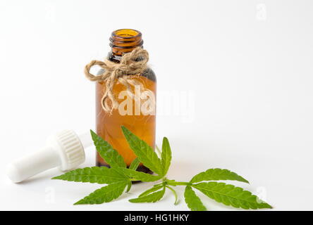 Foglie di cannabis e olio su sfondo bianco Foto Stock