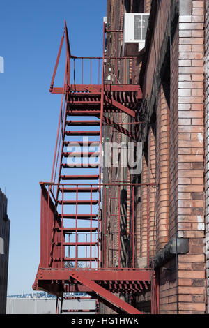 Fire fuoriesce all'esterno di un edificio di appartamenti a New York City. Foto Stock