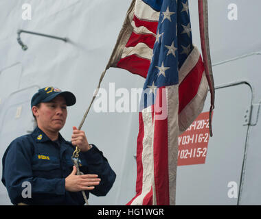 Capo Elettricista di Mate Miranda settimane solleva il ensign come San Antonio-classe di trasporto anfibio dock nave USS San Diego (LPD 22) inizia a discostarsi. Si tratta di settimane nell' ultimo in corso come lei andrà in pensione dopo 20 anni di servizio nel gennaio 2014. (U.S. Foto di Marina di Massa Specialista comunicazione marinaio Gerald Dudley Reynolds/RILASCIATO) USS San Diego di fase di base 131112 formazione-N-QC631-076 Foto Stock