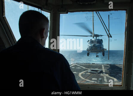 131202-N-PW661-025 Golfo di Oman (dec. n. 2, 2013) Il tenente j.g. Taylor Shipley osserva l'atterraggio di un MH-60R Sea Hawk elicottero, assegnato alla palude volpi di elicottero Maritime Strike Squadron (HSM) 74, dall'elicottero della torre di controllo a bordo del guidato-missile destroyer USS Mason (DDG 87). Mason è distribuito come parte di Harry Truman Carrier Strike gruppo sostenere le operazioni di sicurezza marittima e di teatro la cooperazione in materia di sicurezza gli sforzi negli Stati Uniti Quinta Flotta area di responsabilità. (U.S. Foto di Marina di Massa lo specialista di comunicazione 2a classe Rob Aylward/RILASCIATO) USS Mason 131202 operazioni Foto Stock